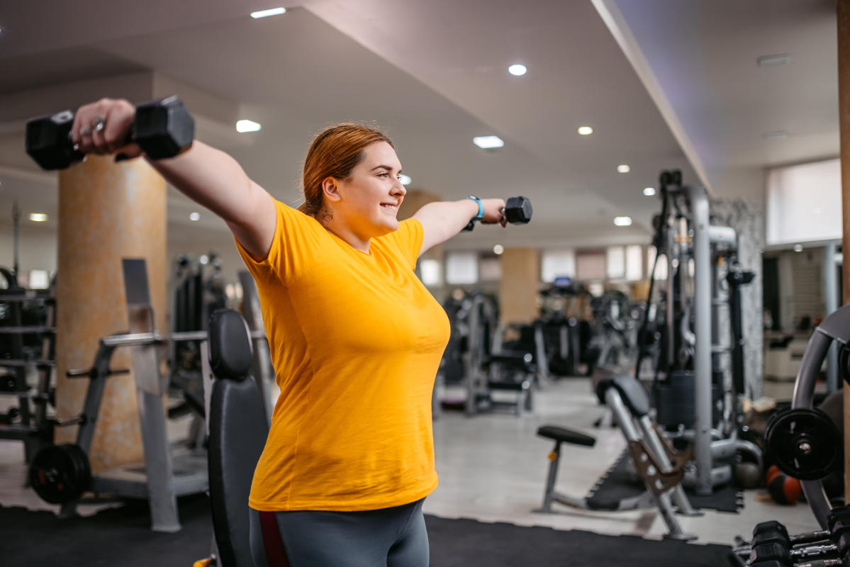 Black-Attired Fitness Enthusiast Strikes a Pose in the Gym