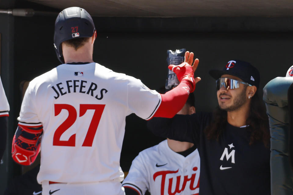 With the celebratory sausage in hand, Minnesota Twins' Ryan Jeffers (27) celebrates after his solo home run against the Boston Red Sox with Pablo Lopez in the third inning of a baseball game Sunday, May 5, 2024, in Minneapolis. (AP Photo/Bruce Kluckhohn)