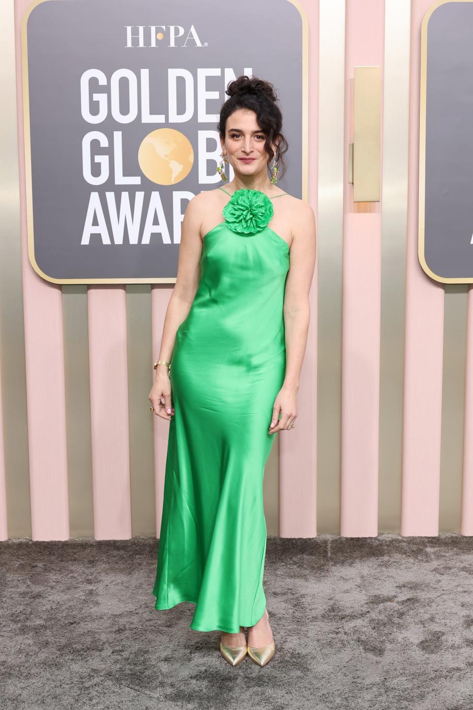 Jenny Slate wearing a green silk halter dress at the 2023 golden globes