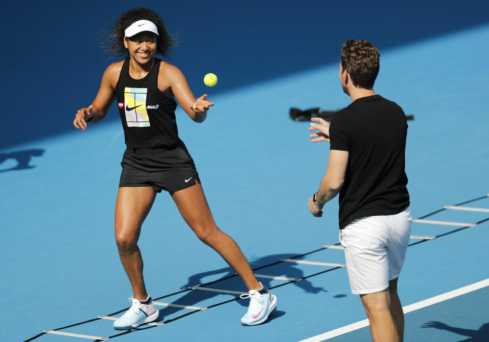 Japan's Naomi Osaka warms-up with her coach Wim Fissette during a practice session ahead of the Australian Open tennis championship in Melbourne, Australia, Sunday, Jan. 19, 2020. (AP Photo/Andy Wong)