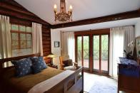 <p>A traditional chandelier and rustic wood paneling work great in this 1920s log cabin. Design by <a href="https://deringhall.com/interior-designers/james-john-flynn" rel="nofollow noopener" target="_blank" data-ylk="slk:James John Flynn;elm:context_link;itc:0;sec:content-canvas" class="link ">James John Flynn</a>. </p>