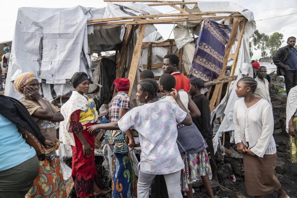 People gather at the side of an explosion in a refugee camp on the outskirts of Goma, Democratic Republic of the Congo, Friday, May, 3, 2024. The Congolese army says a bomb at a refugee camp in eastern Congo has killed at least 5 people, including children. An army spokesman blamed the attack at the Mugunga refugee camp in North Kivu on a rebel group, known as M23, with alleged links to Rwanda, in a statement provided to The Associated Press. (AP Photo/Moses Sawasawa)