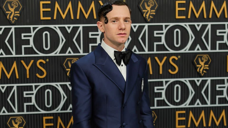 Christ Perfetti’s hairstyle nodded to old Hollywood glamour, with the perfectly gelled curl bringing a feminine accent to his look. The "Abbott Elementary" star wore a glossy dark blue tuxedo by BMC studio, black bowtie and patent leather shoes. - Neilson Barnard/Getty Images