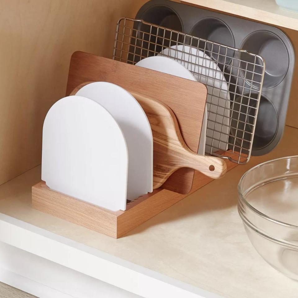 A cookware organizer with cutting boards and baking sheets