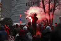 FILE - A protestor lights a flare during a demonstration against the reinforced measures of the Belgium government to counter the latest spike of the coronavirus in Brussels, Belgium, Sunday, Nov. 21, 2021. The coronavirus's omicron variant kept a jittery world off-kilter Wednesday Dec. 1, 2021, as reports of infections linked to the mutant strain cropped up in more parts of the globe, and one official said that the wait for more information on its dangers felt like “an eternity.” (AP Photo/Olivier Matthy, File)