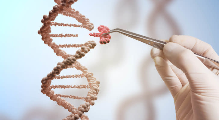 Gene editing stocks: a concept image of a hand holding a pair of tweezers that is pulling a section off of a dna strand