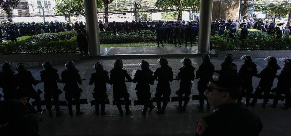 Riot policemen stand guard at the headquarters of the ruling Puea Thai Party of Prime Minister Yingluck Shinawatra in Bangkok