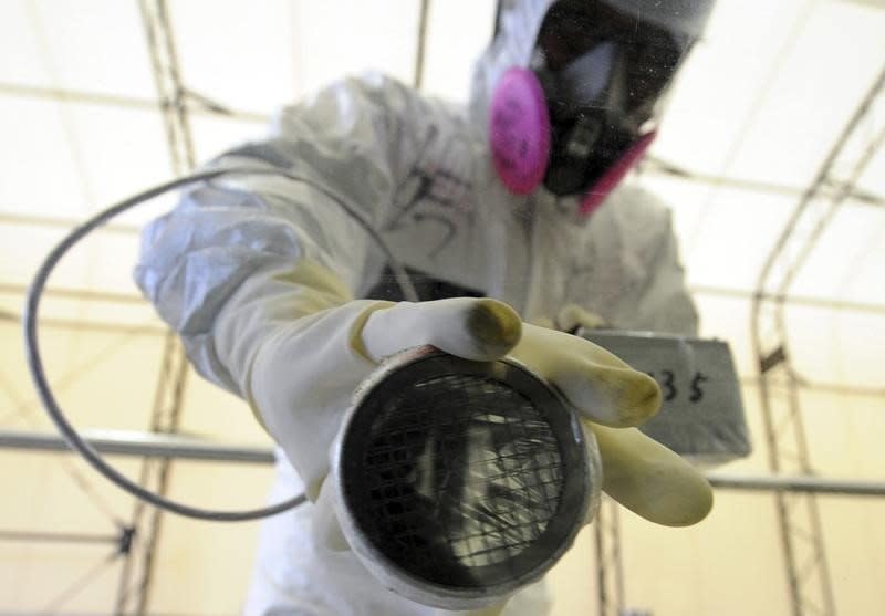 A worker takes radiation readings on the window of a bus at the screening point of the Tokyo Electric Power Company's (TEPCO) tsunami-crippled Fukushima Daiichi nuclear power plant in Fukushima prefecture June 12, 2013.   REUTERS/Toshifumi Kitamura/Pool