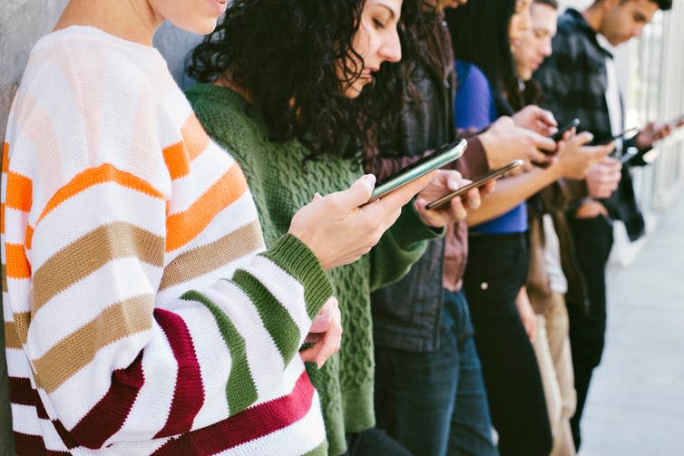 A group of people looking at their phones