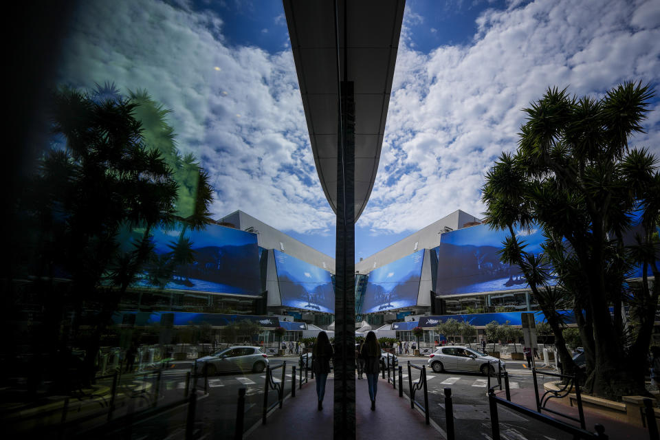 The Palais des festivals is reflected in a shop window during preparations for the 77th international film festival, Cannes, southern France, Monday, May 13, 2024. The Cannes film festival runs from May 14 until May 25, 2024. (AP Photo/Andreea Alexandru)