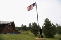 Cattle rancher Arlene Mackay raises the American flag at her ranch in Avon