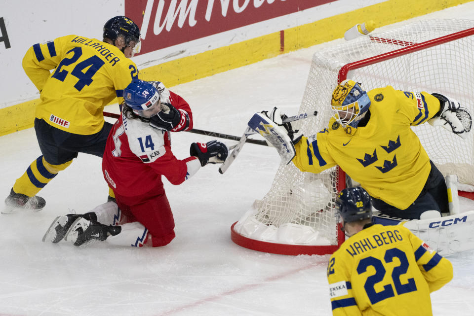 Sweden's Tom Willander (24) is called for slashing on Czechia's Adam Zidlicky (14) as he drives the net past Sweden goaltender Hugo Havelid during the second period of a semifinal hockey game at the IIHF World Junior Hockey Championship in Gothenburg, Sweden, Thursday Jan. 4, 2024. (Christinne Muschi/The Canadian Press via AP)