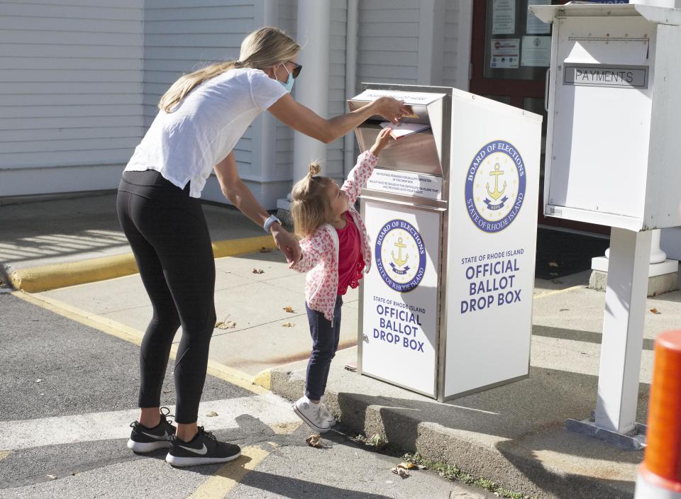 Sloane Barney, 2, helps mom Tina vote early using the official ballot box outside Middletown Town Hall in October 2020.