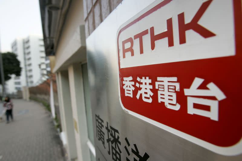 A woman walks past the television house of Radio Television Hong Kong in Hong Kong