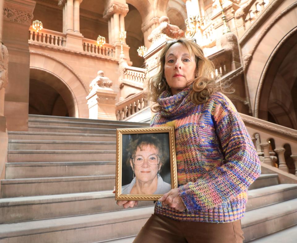 Mary Beth Delarm holds a photo of her mother, Pat Ashley while at the New York State Capitol on April 20, 2022. Ashley died in May 2020 while in a nursing home in Rensselaer County.  