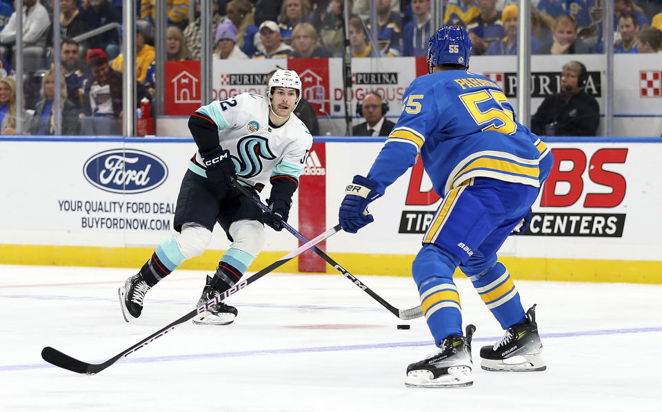 Seattle Kraken's Tye Kartye (52) skates with the puck as St. Louis Blues' Colton Parayko (55) defends during the first period of an NHL hockey game Saturday, Oct. 14, 2023, in St. Louis. (AP Photo/Scott Kane)