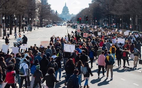 Thousands of local students march down Pennsylvania Avenue from the White House to the US Capitol during a nationwide student walkout for gun control in Washington, DC, March 14, 2018 - Credit: AFP  