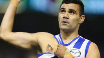 North Melbourne's Lindsay Thomas shows his Aboriginal flag tattoo after kicking a goal.