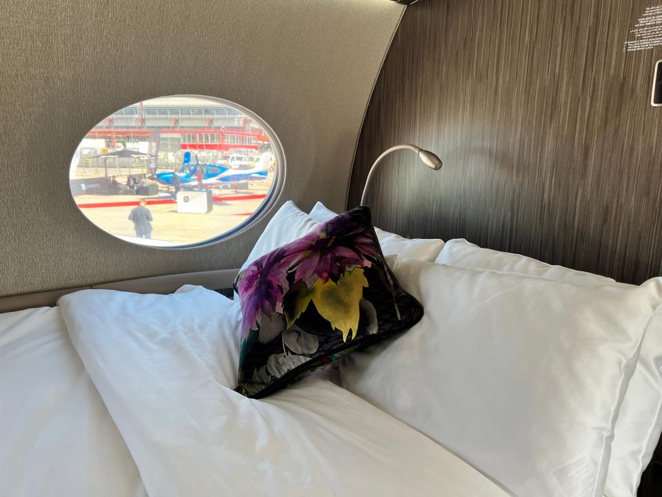 A close up of the bed's pillows and a panoramic window on a Gulfstream G700