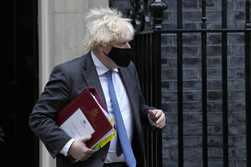 Britain's Prime Minister Boris Johnson leaves 10 Downing Street to attend the weekly Prime Minister's Questions at the Houses of Parliament, in London, Wednesday, Dec. 15, 2021. British lawmakers have voted to approve new restrictions to curb the spread of the omicron coronavirus variant. The House of Commons approved measures ordering masks to be worn indoors in England and requiring proof of vaccination or a negative test to enter nightclubs and large crowded events. (AP Photo/Kirsty Wigglesworth)