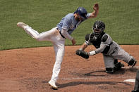 Kansas City Royals' Hunter Dozier, left, is tagged at home by Chicago White Sox catcher Reese McGuire as he tried to score on a single by Kyle Isbel during the fourth inning in the first game of a baseball doubleheader Tuesday, May 17, 2022, in Kansas City, Mo. (AP Photo/Charlie Riedel)