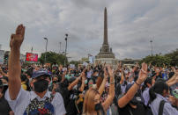 Pro-democracy activists flash three-fingered salute during a demonstration at Victory Monument in Bangkok, Thailand, Wednesday, Oct. 21, 2020. Student activists applied to a Bangkok court Wednesday to revoke a state of emergency the government declared last week to try to rein in Thailand's growing protests. Demonstrations have continued daily in a movement that calls for Prime Minister Prayuth Chan-ocha to step down, for a more democratic constitution and for reforms to the monarchy — a revered institution traditionally treated as sacrosanct in Thailand. (AP Photo/Sakchai Lalit)