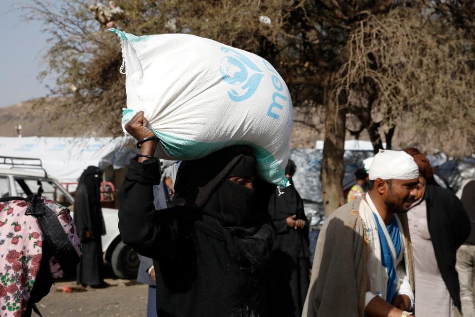 A displaced Yemeni woman gets emergency food aid on the outskirts of Sana’a (EPA)