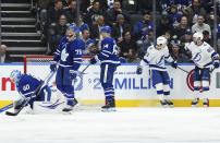 Tampa Bay Lightning's Brayden Point (21) celebrates his goal against Toronto Maple Leafs' goaltender Joseph Woll (60) with Nikita Kucherov (86) during the second period of an NHL hockey game Wednesday, April 3, 2024, in Toronto. (Chris Young/The Canadian Press via AP)