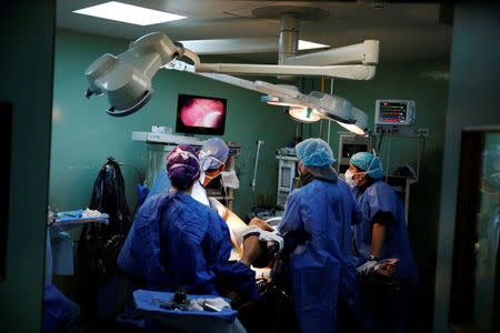 Surgeons carry out a sterilization on a patient in an operating room at a hospital in Caracas, Venezuela July 27, 2016. REUTERS/Carlos Garcia Rawlins