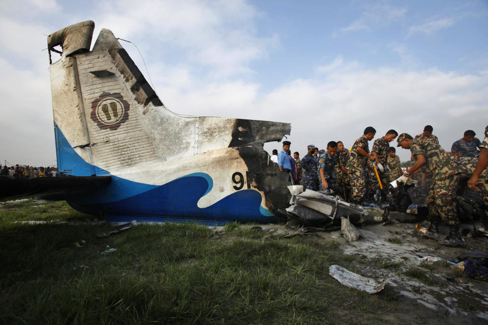 Nepalese police search through the debris at the crash site of a Sita Air airplane near Katmandu, Nepal, early Friday, Sept. 28, 2012.  The plane carrying trekkers into the Everest region crashed just after takeoff Friday morning in Nepal's capital, killing all 19 people on board, authorities said. (AP Photo/Niranjan Shrestha)