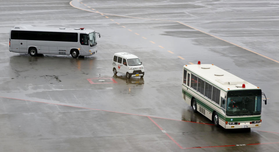 Vehicles carrying men who appear to be Michael Taylor and Peter Taylor, move on tarmac at Narita Airport in Narita, east of Tokyo, Tuesday, March 2, 2021. Two Americans suspected of helping former Nissan Chairman Carlos Ghosn skip bail and escape to Lebanon in December 2019 have been extradited to Japan. Taylor and his son Peter had been held in a suburban Boston jail since May. They were handed over to Japanese custody on Monday and were due to arrive in Tokyo on Tuesday. (Sadayuki Goto/Kyodo News via AP)