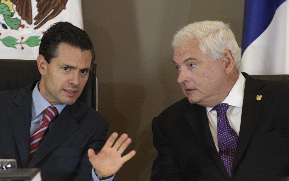 Mexico's President Enrique Pena Nieto, left, and Panama's President Ricardo Martinelli talk prior to signing a Free Trade Agreement between both countries during the last day of the World Economic Forum on Latin America in Panama City, Thursday, April 3, 2014. (AP Photo/Arnulfo Franco)