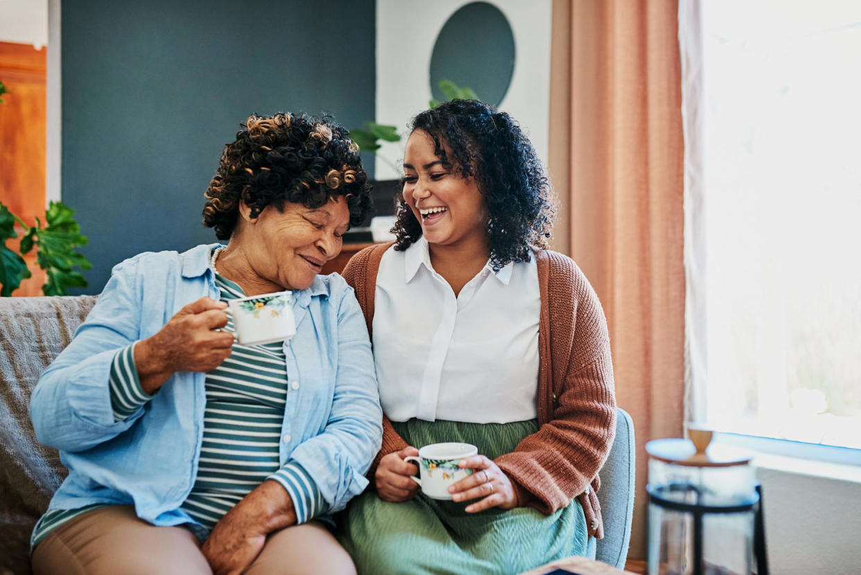 Shot of a young woman having coffee with her relative on the sofa at home (Adene Sanchez / Getty Images)