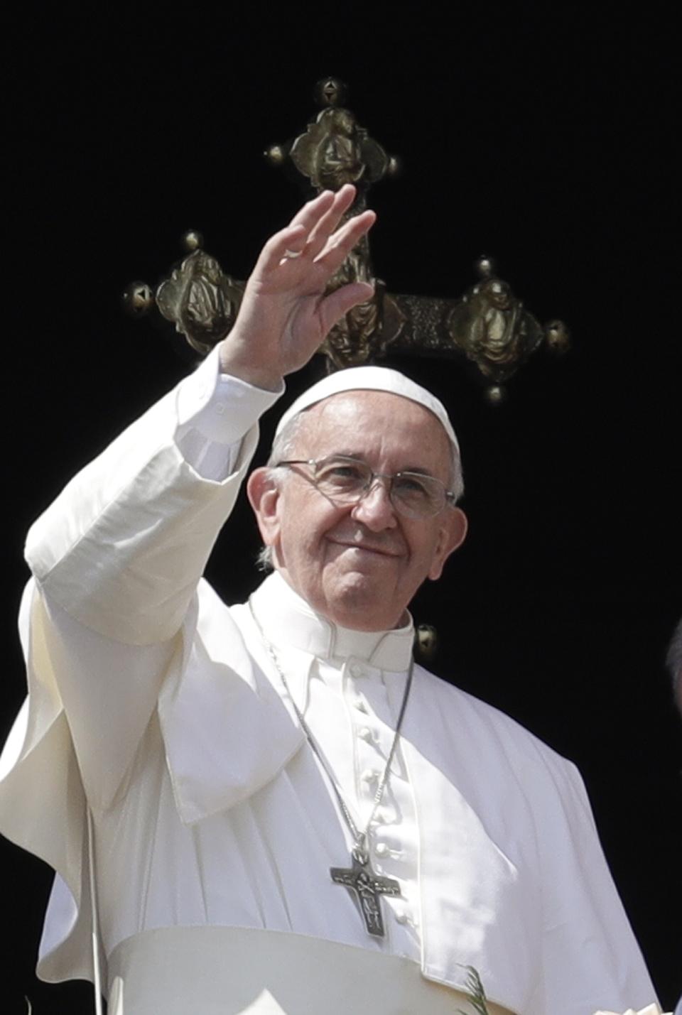 Pope Francis waves after celebrating Easter Sunday Mass, from the main balcony of in St. Peter's Basilica, at the Vatican, Sunday, April 16, 2017. (AP Photo/Gregorio Borgia)