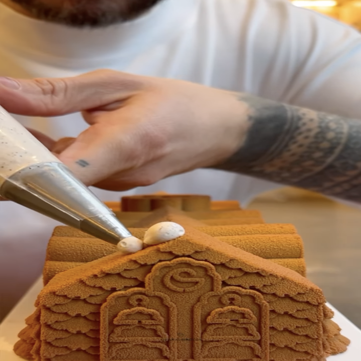 cedric decorating a gingerbread house shaped yule log