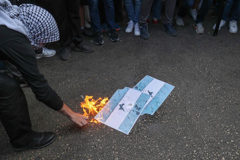 Estudiantes de la Universidad Americana de Beirut (AUB) queman banderas de Israel durante una manifestación en apoyo a los palestinos frente a la puerta principal de la universidad en la capital libanesa el 9 de octubre de 2023.