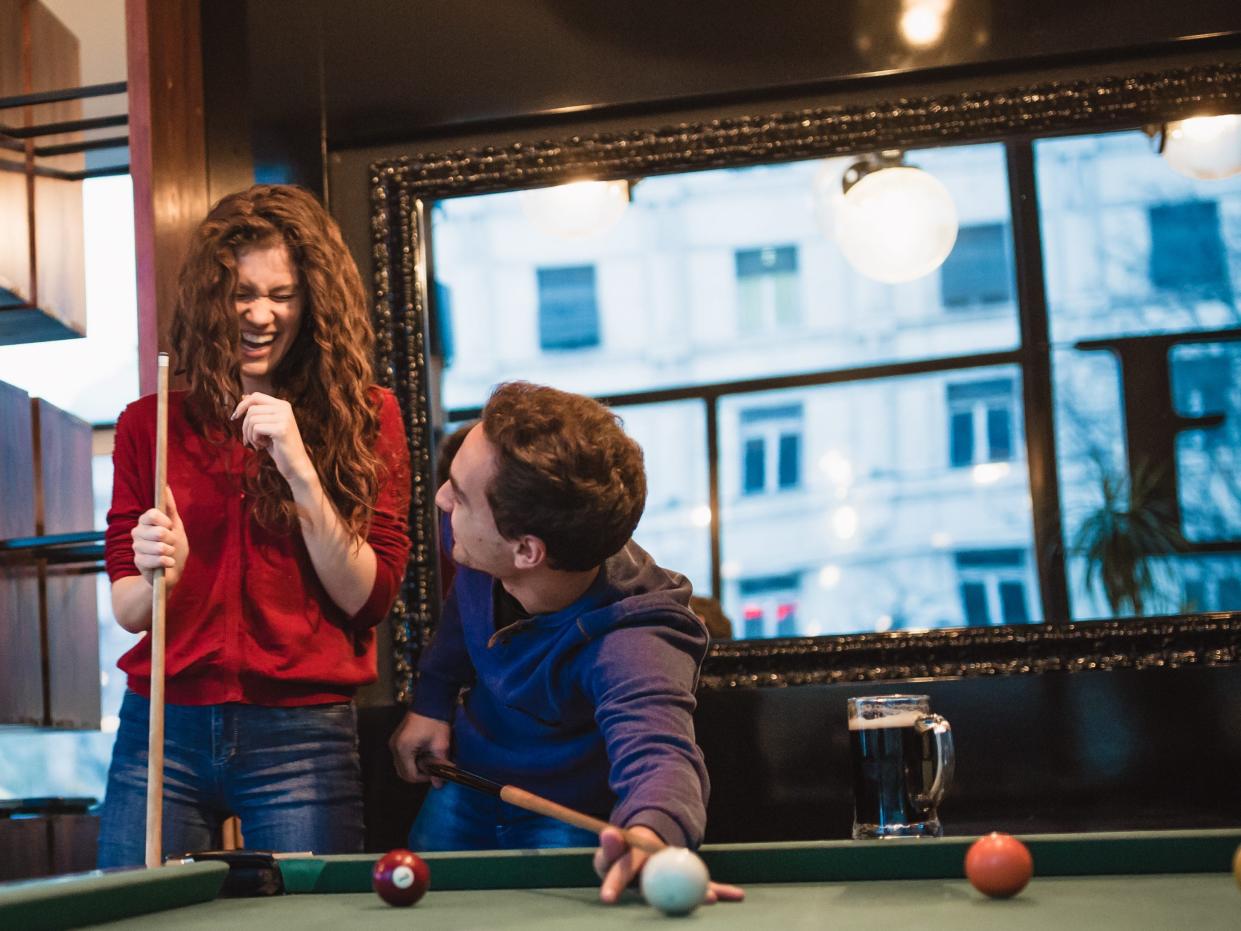 Group of friends spending time together, drinking beer, playing snooker - stock photo