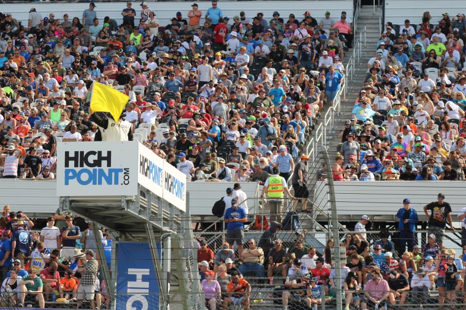 An official waves a yellow flag during the NASCAR Cup Series race at Pocono Raceway on Sunday, July 23, 2023.