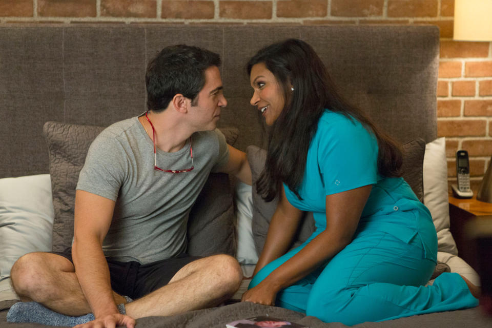 asian woman and white man sitting in bed