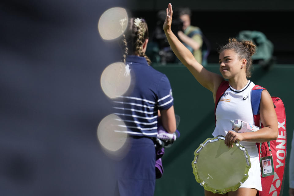 Jasmine Paolini of Italy waves to the crowd as she leaves court with her runner-up trophy after she lost to Barbora Krejcikova of the Czech Republic in the women's singles finalat the Wimbledon tennis championships in London, Saturday, July 13, 2024. (AP Photo/Mosa'ab Elshamy)