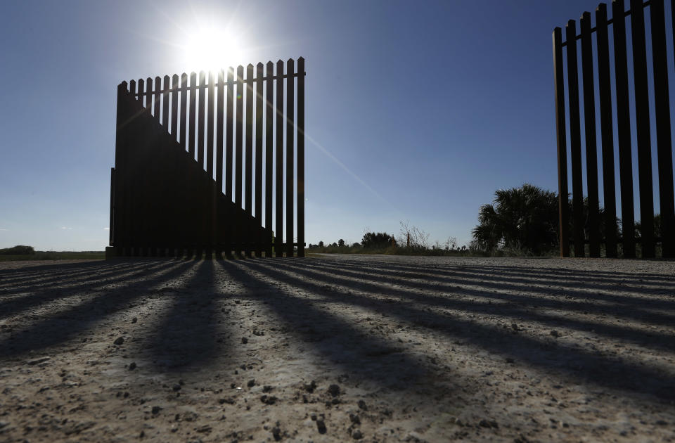 In this Sept. 4, 2012, photo, the sun casts a shadow on the U.S.-Mexico border fence that passes through the Nature Conservancy's southernmost preserve in Brownsville, Texas. Since 2008, hundreds of landowners on the border have sought fair prices for property that was condemned to make way for the fence, but many of them received initial offers that were far below market value. (AP Photo/Eric Gay)