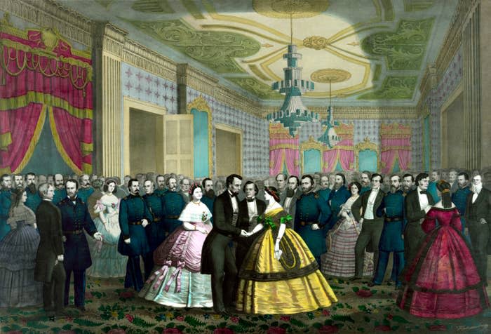 Abraham Lincoln and Mary Todd Lincoln dance in a crowded ballroom filled with people in 19th-century formal attire