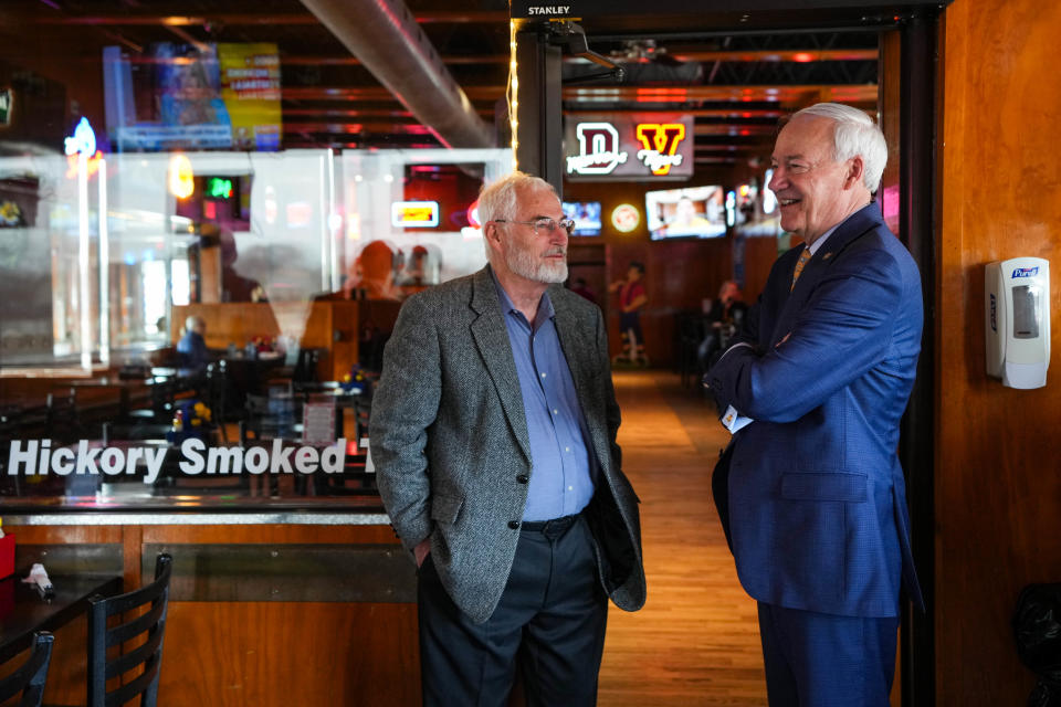 Former Gov. of Arkansas Asa Hutchinson, right, talks with Kim Schmett at Jethro's BBQ 'n Bacon in West Des Moines on Wednesday, March 29, 2023.