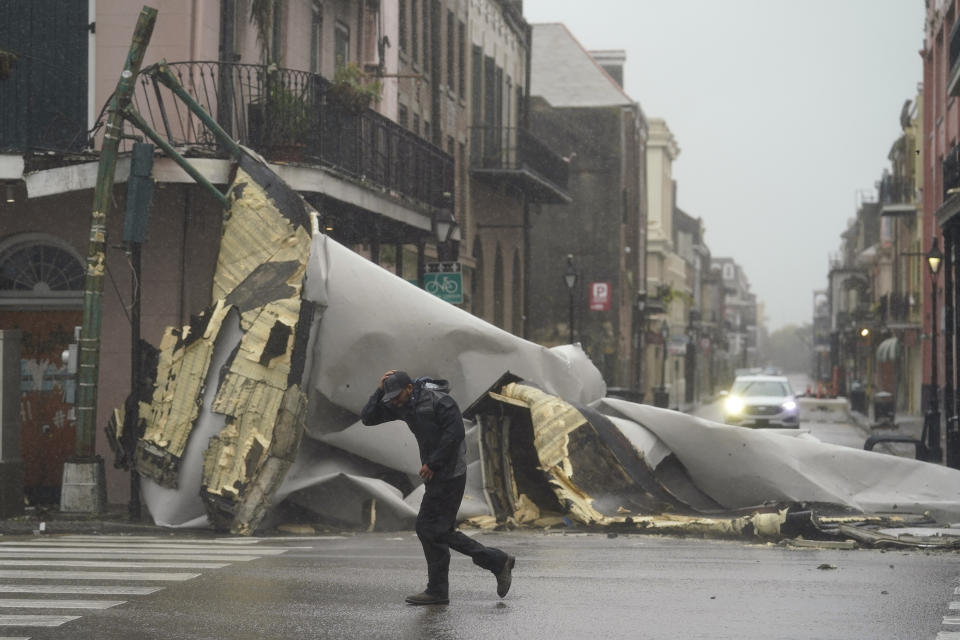 A man passes by a section of roof that was blown off of a building in the French Quarter in New Orleans by Hurricane Ida winds on Sunday (local time). Source: AP