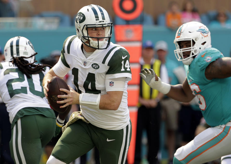 FILE- In this Sunday, Nov. 4, 2018, file photo, New York Jets quarterback Sam Darnold (14) looks to pass, during the first half of an NFL football game against the Miami Dolphins in Miami Gardens, Fla. Many teams think it's best to throw rookie QBs right into the fire to learn on the job. Others prefer to gradually work them into the offense. Then, there are some who believe it's more beneficial to have them grab a cap and a clipboard and take it all in from the sideline. (AP Photo/Lynne Sladky, File)