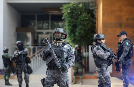 Police officers stand guard outside a building where drug kingpin Damaso Lopez, nicknamed "The Graduate", was arrested in Mexico City, Mexico May 2, 2017. REUTERS/Henry Romero