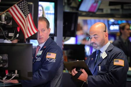 FILE PHOTO: Traders work on the floor at the NYSE in New York