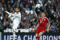 Real's Sergio Ramos kicks the ball next to Bayern's Bastian Schweinsteiger, right, during a first leg semifinal Champions League soccer match between Real Madrid and Bayern Munich at the Santiago Bernabeu stadium in Madrid, Spain, Wednesday, April 23, 2014. (AP Photo/Andres Kudacki)