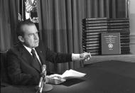 FILE - In this April 29, 1974 file photo, President Richard M. Nixon points to the transcripts of the White House tapes in Washington, after he announced on television that he would turn over the transcripts to House impeachment investigators. The public impeachment inquiry hearings this week usher in a rare and momentous occasion in American history as Congress debates whether to remove a sitting president from office. (AP Photo/File)