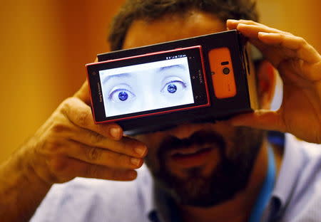 A visitor puts on "Truth?", a pair of goggles made by students from Keio University in Japan, that projects the "true emotions" of a person by monitoring the patterns of his or her heartbeat, during a design competition showcase of wearable technology at the Augmented Human International Conference in Singapore in this March 10, 2015 file photo. REUTERS/Edgar Su/Files